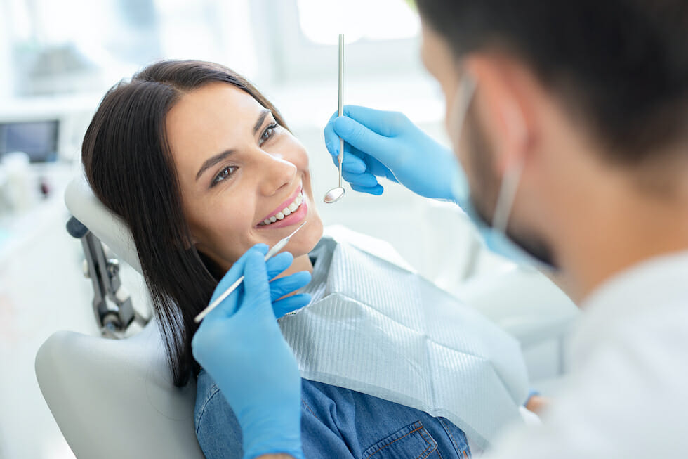 woman smiling while getting dental cleaning